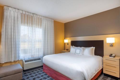 a hotel room with a large bed and a window at TownePlace Suites Huntsville in Huntsville