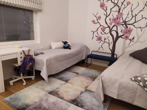 um quarto com uma cama e um mural de árvore na parede em Rauhallisella paikalla upea iso omakotitalo. em Kajaani