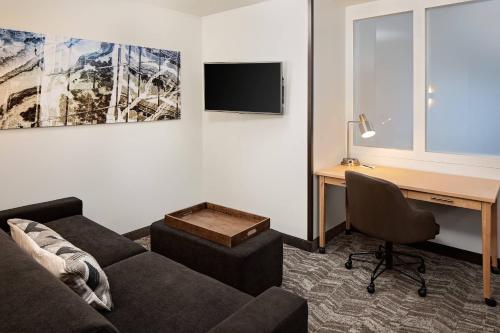 a living room with a couch and a desk with a computer at SpringHill Suites by Marriott Green Bay in Green Bay