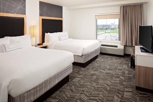 a hotel room with two beds and a flat screen tv at SpringHill Suites by Marriott Green Bay in Green Bay
