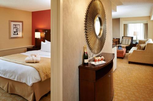 a hotel room with a bed and a mirror at Detroit Marriott Livonia in Livonia