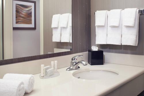 a bathroom with a sink and a mirror and towels at Courtyard Cleveland Independence in Independence