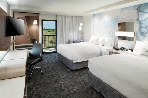 een hotelkamer met 2 bedden en een bureau bij Courtyard by Marriott Fort Worth Alliance Town Center in Fort Worth