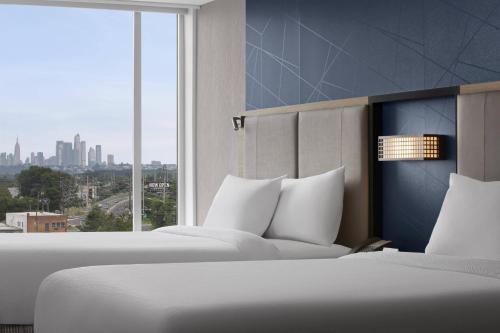 duas camas num quarto de hotel com uma grande janela em SpringHill Suites by Marriott East Rutherford Meadowlands Carlstadt em Carlstadt