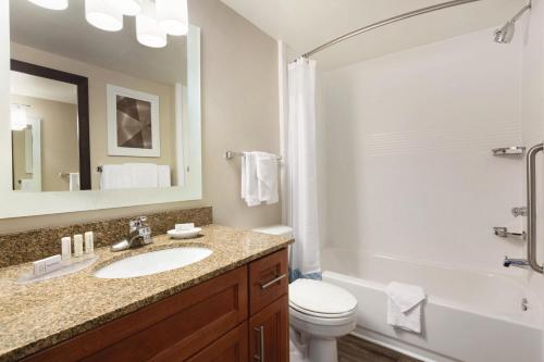 a bathroom with a sink and a toilet and a mirror at TownePlace Suites by Marriott Boulder Broomfield/Interlocken in Broomfield