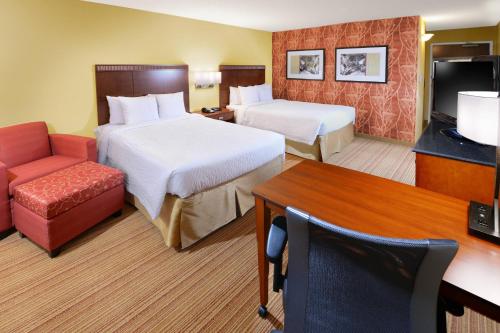 a hotel room with two beds and a television at Courtyard by Marriott Dallas Plano in Legacy Park in Plano