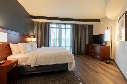una camera d'albergo con un grande letto e una TV di Courtyard by Marriott Cincinnati Midtown/Rookwood a Cincinnati