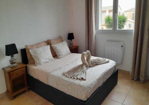 sypialnia z łóżkiem z łukiem w obiekcie Villa avec plage à pied et grande piscine w mieście Sainte-Marie-la-Mer