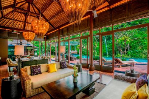 a living room with a couch and a table at Mandapa, a Ritz-Carlton Reserve in Ubud