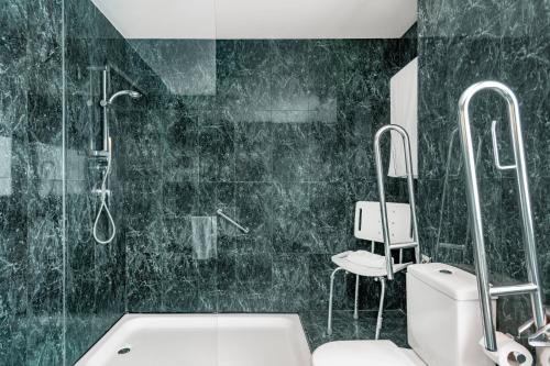 e bagno con doccia, servizi igienici e lavandino. di AC Hotel Badajoz by Marriott a Badajoz