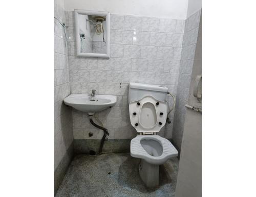 a bathroom with a toilet and a sink at Hotel Swagat, Jammu in Jammu