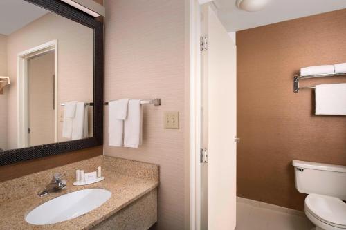 Fairfield Inn & Suites by Marriott Albuquerque Airport في ألباكيركي: حمام مع حوض ومرحاض ومرآة
