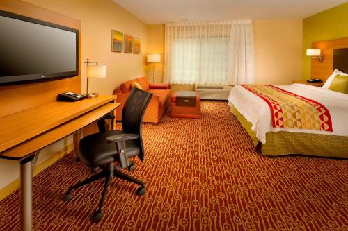 a hotel room with a bed and a desk with a computer at TownePlace Suites Bridgeport Clarksburg in Bridgeport