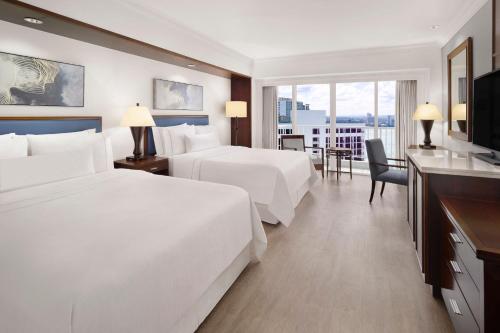 a hotel room with two beds and a television at The Westin Resort Guam in Tumon