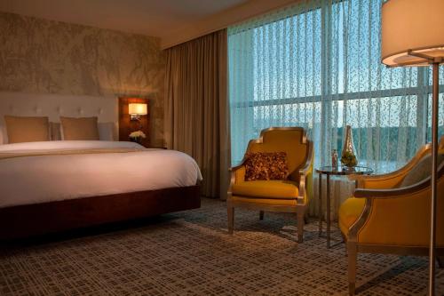 une chambre d'hôtel avec un lit, une chaise et une fenêtre dans l'établissement Renaissance Baton Rouge Hotel, à Bâton-Rouge