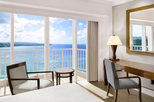 a hotel room with a desk and a view of the ocean at The Westin Resort Guam in Tumon