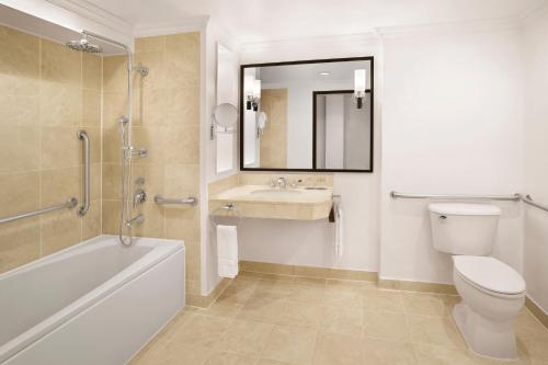 a bathroom with a toilet and a sink and a mirror at The Westin Resort Guam in Tumon