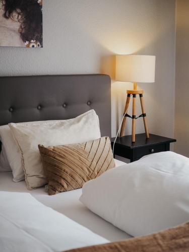a bedroom with a bed with a lamp on a table at Roudenhaff Guestfarm in Echternach