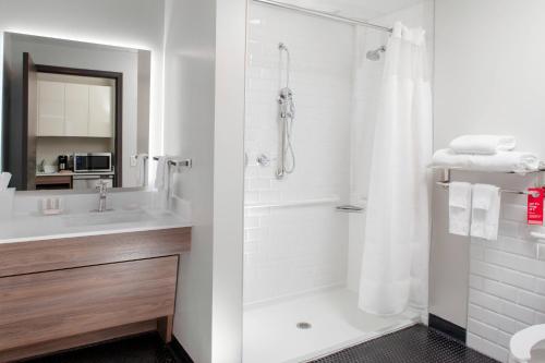 a white bathroom with a shower and a sink at TownePlace Suites by Marriott Dallas Downtown in Dallas