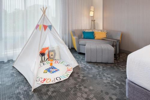 Zimmer mit einem Bett und einem Spielzelt in der Unterkunft Courtyard by Marriott Atlanta Alpharetta/Avalon Area in Alpharetta