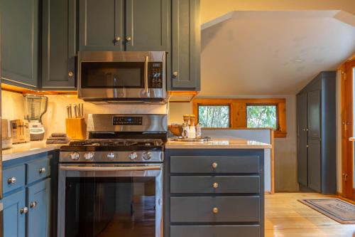 a kitchen with a stove and a microwave at Beech Haven in Beech Mountain