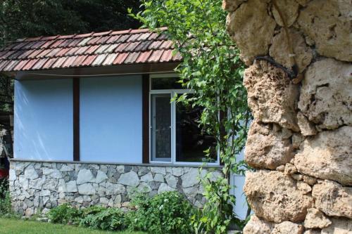 a stone house with a red roof and a window at Eco Garden Dilijan in Dilijan