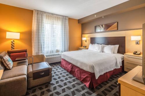 ジャクソンビルにあるTownePlace Suites Jacksonville Butler Boulevardのベッドとソファ付きのホテルルーム