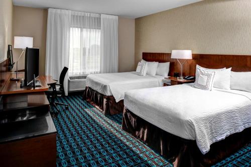 a hotel room with two beds and a television at Fairfield Inn & Suites by Marriott Lansing at Eastwood in Lansing