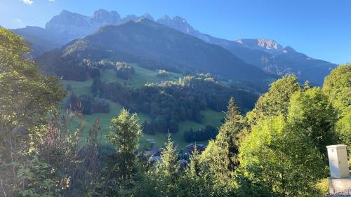 a view of a valley with trees and mountains at Val D’Illiez mountain apartment. in Val dʼIlliez