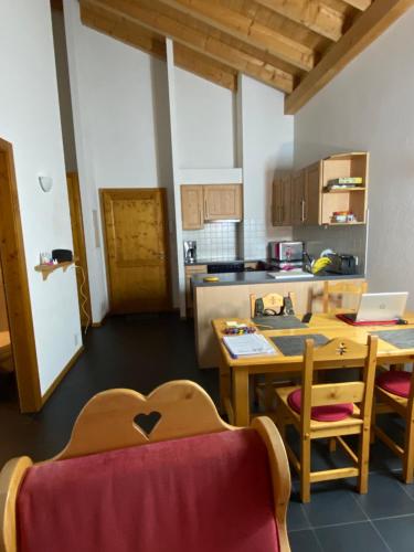 Habitación con cocina con mesa y mesa. en Val D’Illiez mountain apartment. en Val dʼIlliez