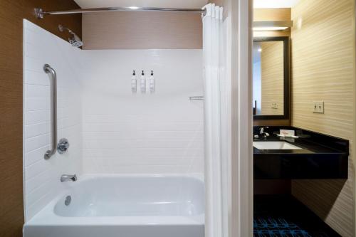 a bathroom with a white tub and a sink at Fairfield Inn & Suites by Marriott Denver Aurora/Medical Center in Aurora