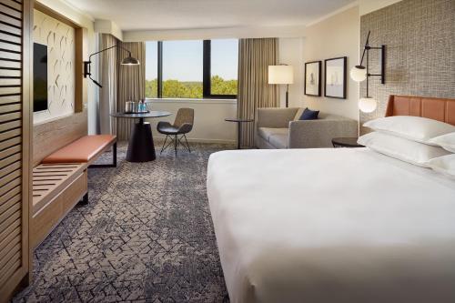 a hotel room with a bed and a living room at Sheraton Imperial Hotel Raleigh-Durham Airport at Research Triangle Park in Durham