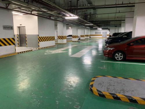 a parking lot with cars parked in a parking garage at SMDC Grass Residences in Manila