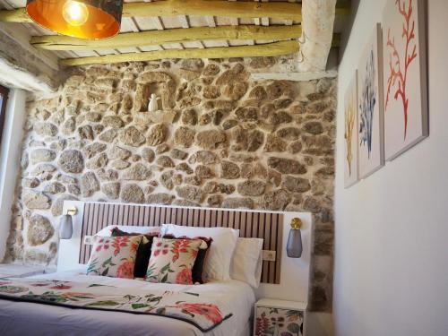- une chambre avec un mur en pierre et un lit dans l'établissement La Casa Rebonita ACCESA, à Candelario