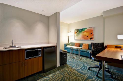 SpringHill Suites by Marriott Baltimore BWI Airport في لينثيكوم هايتس: غرفه فندقيه مع مطبخ وصاله