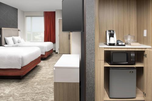 a hotel room with two beds and a tv at SpringHill Suites by Marriott Loveland Fort Collins/Windsor in Windsor