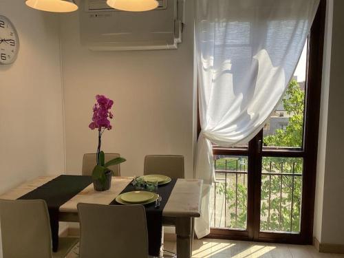 comedor con mesa y ventana en Diego's Apartment - Monza Park, en Biassono