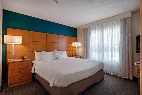 een hotelkamer met een bed en een groot raam bij Residence Inn by Marriott Atlantic City Airport Egg Harbor Township in Egg Harbor Township