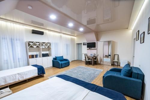 um quarto com 2 camas, um sofá e uma mesa em Tiflis Hotel em Tbilisi