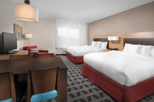 a hotel room with two beds and a table and a desk at TownePlace Suites by Marriott Nashville Smyrna in Smyrna