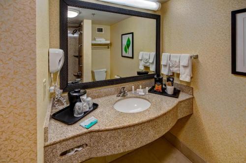 Un baño con lavabo y un espejo grande. en Spark by Hilton Murfreesboro, en Murfreesboro