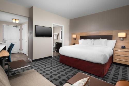 ein Hotelzimmer mit einem großen Bett und einem Schreibtisch in der Unterkunft TownePlace Suites by Marriott Nashville Smyrna in Smyrna