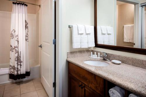 ein Bad mit einem Waschbecken, einem Spiegel und einer Dusche in der Unterkunft Residence Inn by Marriott Billings in Billings