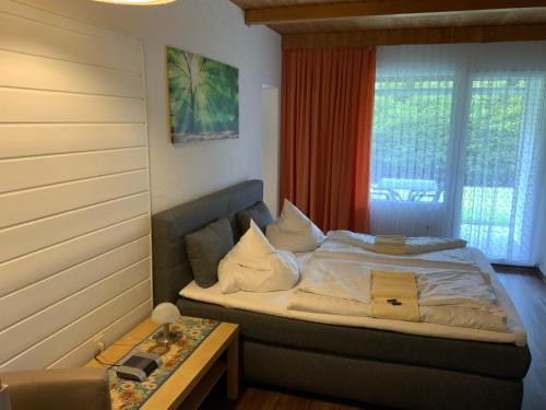 sypialnia z łóżkiem z oknem i stołem w obiekcie Hotel Schachten w mieście Lindberg