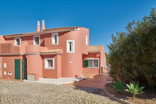 a large pink house with a cobblestone street at Panorama Castro Marim - Deluxe Villa With Pool in Castro Marim