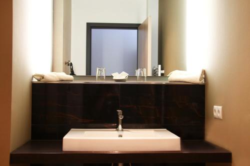 y baño con lavabo y espejo. en Sporthotel Racket Inn, en Hamburgo