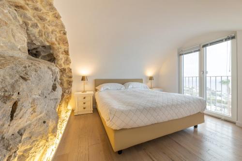 a bedroom with a bed and a large stone wall at Casa Boutique by Capri 5 Senses in Capri