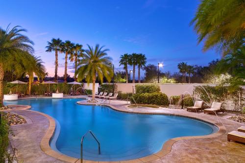 a swimming pool with palm trees and chairs in a resort at The Westin Lake Mary, Orlando North in Lake Mary