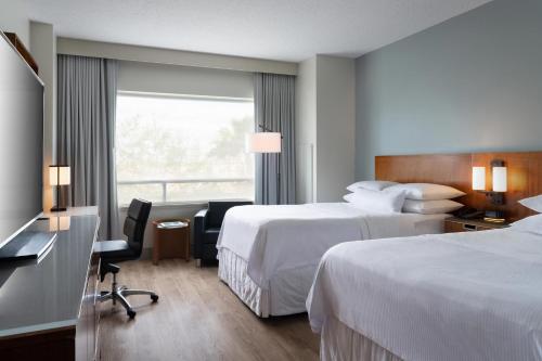 a hotel room with two beds and a desk at The Westin Lake Mary, Orlando North in Lake Mary