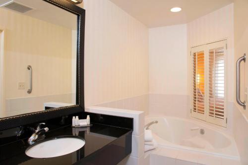 a bathroom with a sink and a tub and a mirror at Fairfield Inn & Suites by Marriott Omaha Downtown in Omaha